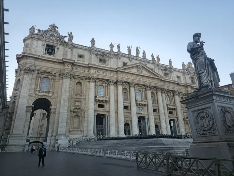 The facade of St Peter's Basilica, with a statue in the foreground