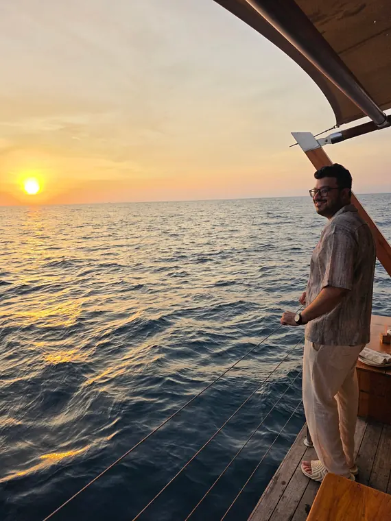 Sandeep on the deck of a boat at sunset over the Andaman Sea