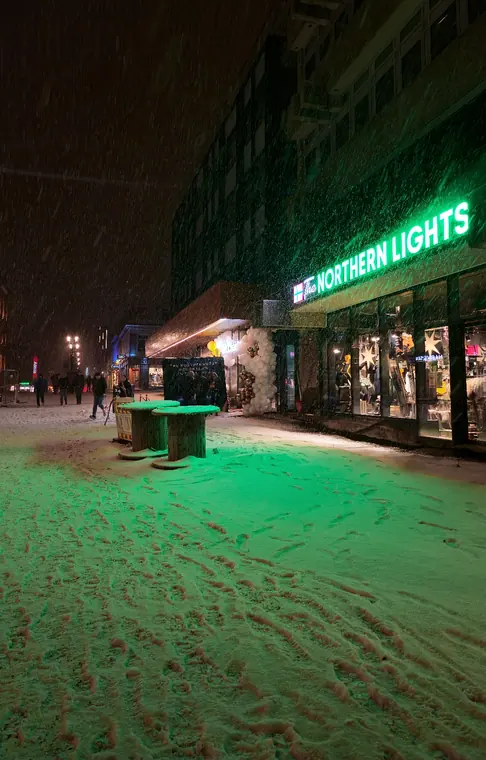 Snow falling on Tromsø's main street at night